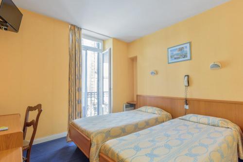 a bedroom with two beds and a window at Hotel Acapulco in Lourdes