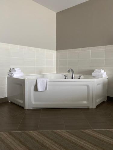 a bathroom with a bath tub with towels on it at Country Inn & Suites by Radisson, Bemidji, MN in Bemidji