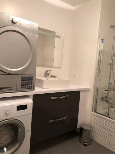 une salle de bain avec une machine à laver et un lavabo dans l'établissement Appartement T4 8 personnes 1ère ligne Bassin d'Arcachon, à Arcachon