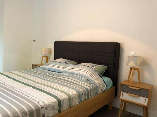 - un lit avec une tête de lit noire dans une chambre dans l'établissement Appartement T4 8 personnes 1ère ligne Bassin d'Arcachon, à Arcachon