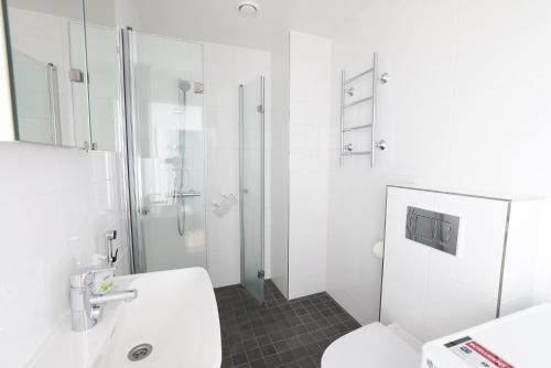 a white bathroom with a toilet and a shower at 2ndhomes Cozy 44m2 1BR home with best location in Kamppi! in Helsinki