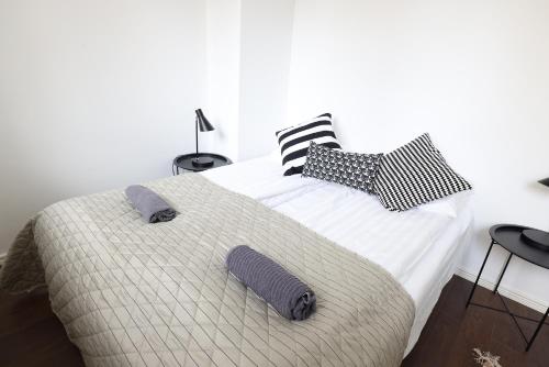 Un dormitorio con una cama grande con almohadas. en 2ndhomes Cozy 44m2 1BR home with best location in Kamppi!, en Helsinki