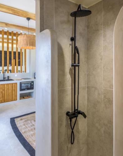 a shower in a bathroom with a wall at Ocean Pearl Luxurious Suite in Pachaina