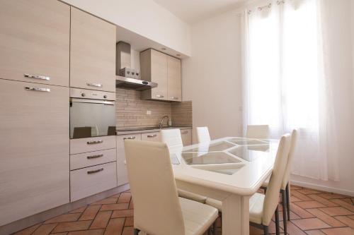 kuchnia ze szklanym stołem i białymi szafkami w obiekcie 45 - Tourist House Bologna Oberdan - Self check-in w Bolonii