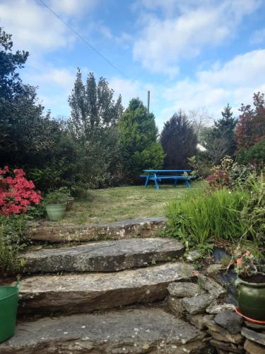 a set of stone steps leading to a blue picnic table at Sea Lodge B&B in Durrus