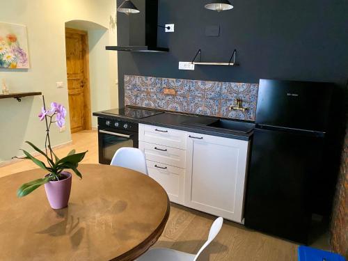 a kitchen with a table and a black refrigerator at La Chicca del Centro in La Spezia