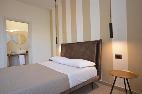 a bedroom with a bed and a stool and a mirror at Cala di Ponente in Castelluzzo