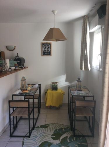 una habitación con 2 mesas y una mesa amarilla en Résidence domaine des sables ROUTE 66 en Soulac-sur-Mer