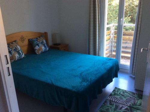una camera con letto e copriletto blu di Résidence domaine des sables ROUTE 66 a Soulac-sur-Mer