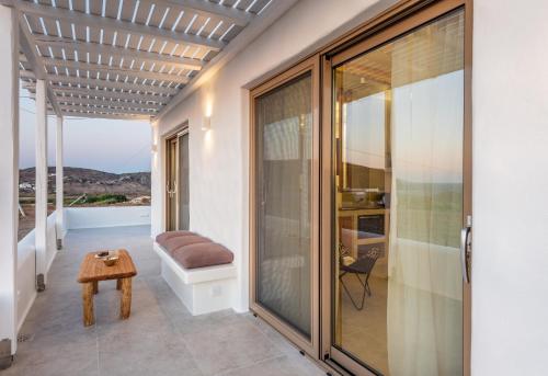 a room with a balcony with a bench and a table at Ocean Pearl Luxurious Suite in Pachaina