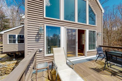 a home with a deck with chairs and windows at Swaying Pines in Wilmington