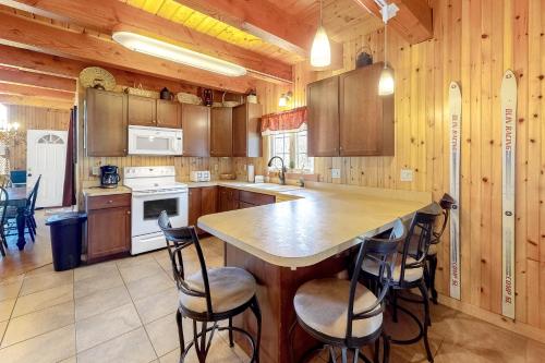 a kitchen with wooden cabinets and a island with bar stools at Swaying Pines in Wilmington
