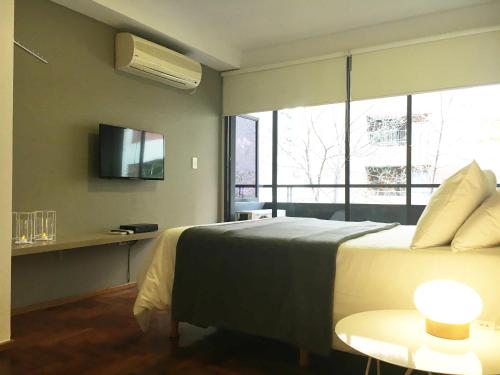a bedroom with a large bed and a window at Departamentos Lugar in Cordoba
