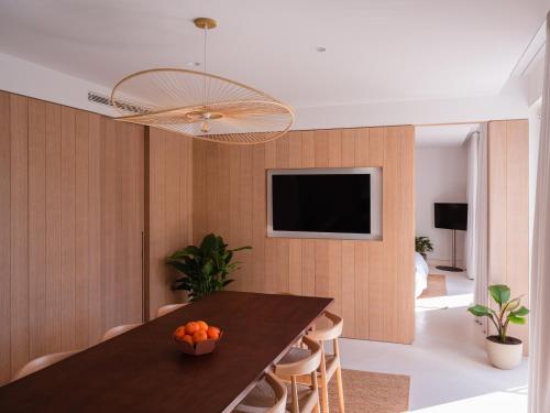 a dining room with a table and a television at The Standard, Ibiza in Ibiza Town