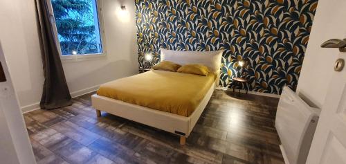 een slaapkamer met een bed met gele lakens en behang bij OISEAU DE PARADIS - 7 Min des Parcs Walt Disney- Arrivée autonome-Parking et Wifi gratuit- Proche commerces et restaurant Idéal pour les familles in Magny-le-Hongre