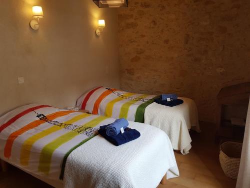 two beds in a room with towels on them at Monpazier Situation idéale Lumineux Terrasse in Monpazier