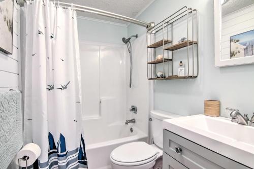 a white bathroom with a toilet and a sink at Walk to Maryland Beach Coastal Condo with Balcony in Ocean City