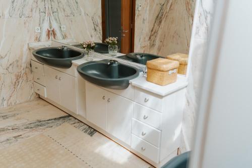 a bathroom with two sinks and a mirror at Regina Beach - Villa with Private Pool in Viana do Castelo