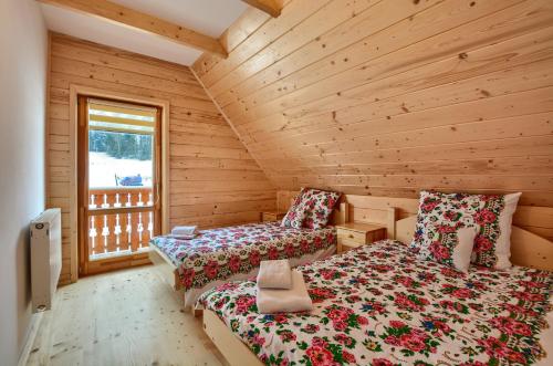 a bedroom with two beds in a log cabin at Domki Stochowa Śleboda in Bukowina Tatrzańska