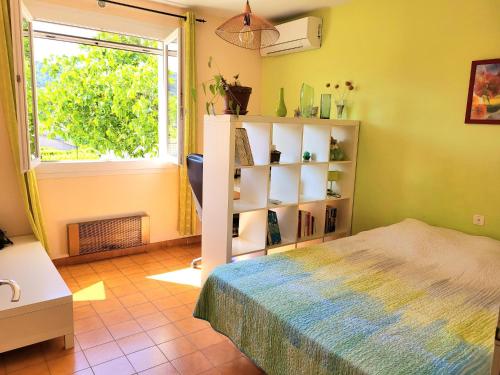 une chambre avec un lit et une fenêtre dans l'établissement Villa Bel-horizon, soleil du sud, à Bagnols-sur-Cèze