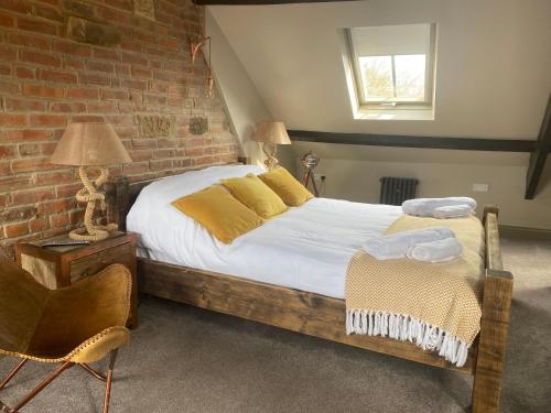 a bedroom with a bed and a brick wall at Newgate House in Morpeth