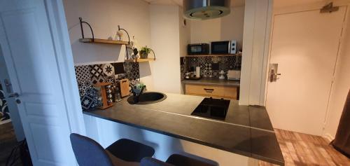 a kitchen with a sink and a counter top at OISEAU DE PARADIS - 7 Min des Parcs Walt Disney- Arrivée autonome-Parking et Wifi gratuit- Proche commerces et restaurant Idéal pour les familles in Magny-le-Hongre