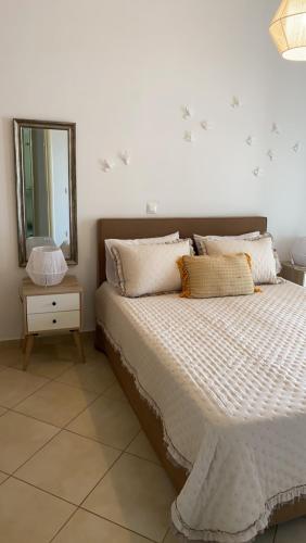 a bedroom with a bed with a mirror on the wall at Theasis apartment in Pera Gyalos