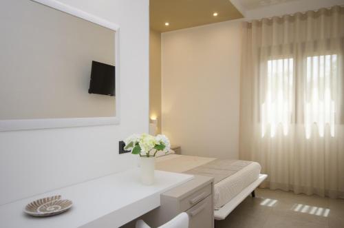 カステッルッツォにあるCala di Ponenteの白いベッドルーム(ベッド1台、花瓶付)