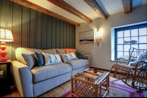 a living room with a couch and a table at The Old Crab Shop. PERFECT location & sea views. in Cromer