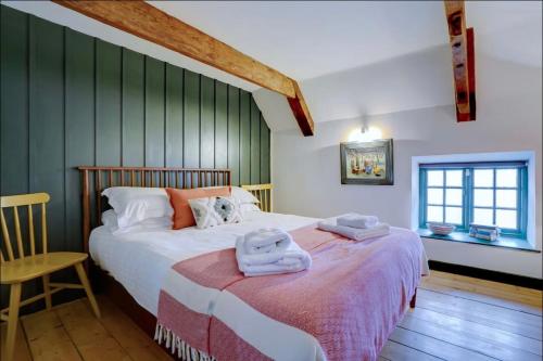 a bedroom with a bed with towels on it at The Old Crab Shop. PERFECT location & sea views. in Cromer