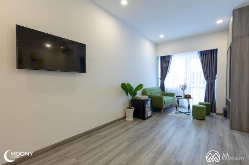 uma sala de estar com uma televisão de ecrã plano na parede em Nha Trang Moony Hotel em Nha Trang