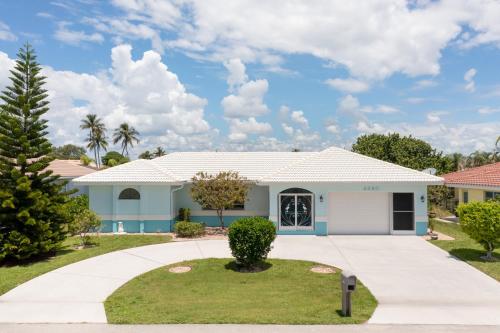 a white house with a driveway at Reduced Rates - Waterfront Heated Pool Home with dock, grill, near Fisherman's Village in Punta Gorda