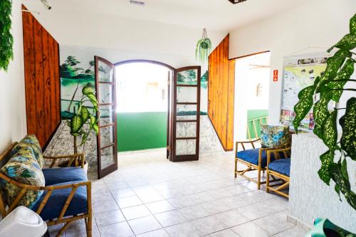 a room with two chairs and a hallway with shelves at San Marino Hotel in Itanhaém