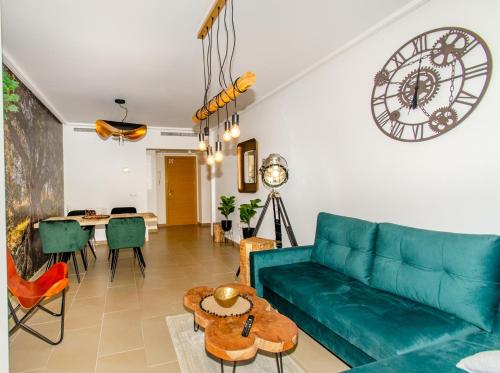 een woonkamer met een blauwe bank en een tafel bij Jardines de Las Marinas con una gran terraza in Denia