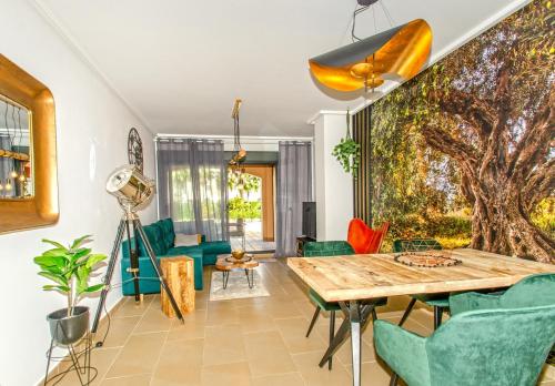 een woonkamer met een houten tafel en groene stoelen bij Jardines de Las Marinas con una gran terraza in Denia