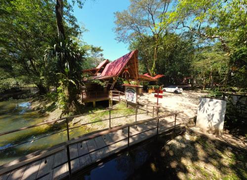 a house with a bridge next to a river at Cabañas Kin Balam Palenque in Palenque