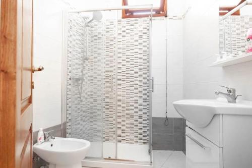 e bagno con doccia, servizi igienici e lavandino. di Sinis Holiday House a Oristano