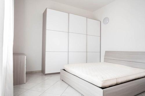 a white bedroom with a bed with white walls at Sinis Holiday House in Oristano