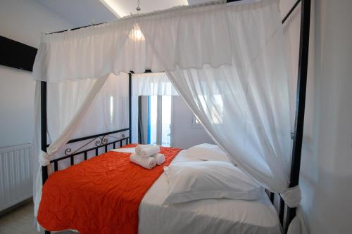 a bedroom with a bed with a teddy bear on it at Hotel Lodos in Karterados