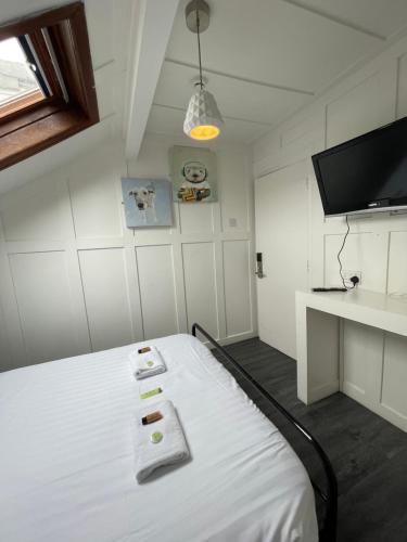 a room with a bed with a tv and a desk at Elmora House in Blackpool