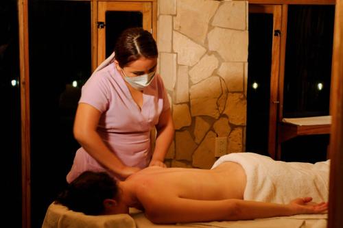 a woman is giving a man a massage at Cabañas Kin Balam Palenque in Palenque