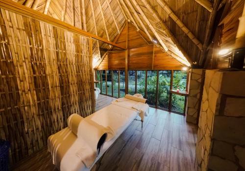 a room with a bed in a bamboo house at Cabañas Kin Balam Palenque in Palenque