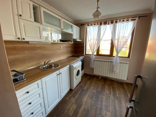 una cucina con lavello e lavatrice di Апартамент "Вила Аква" a Burgas
