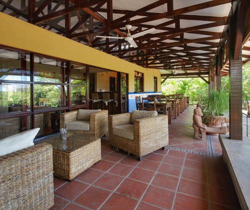 an outdoor patio with chairs and tables and windows at Private Pool & WiFi in Puntarenas
