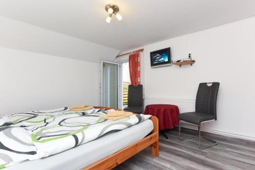 1 dormitorio con 1 cama y 2 sillas en Pension Pradler Zimmer Erdgeschoß en Carolinensiel