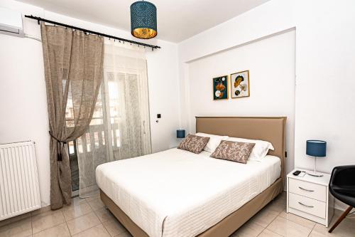 ハニア・タウンにあるKoum Kapi Mare Seaside Cozy Apartment with Private Parkingの白いベッドルーム(ベッド1台、窓付)