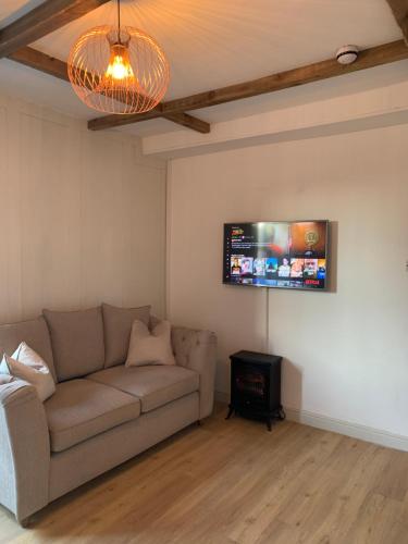 a living room with a couch and a flat screen tv at Cosy 1st floor Flat - Kendal Lake District with bike storage in Kendal