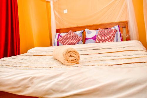 een bed met een opgerolde handdoek erop bij Almasi Place in Nairobi