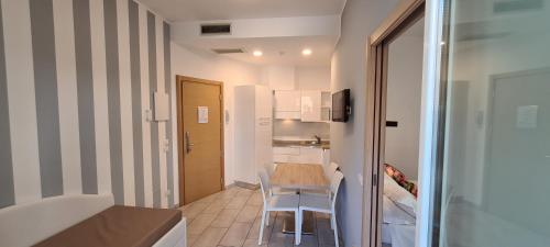 una piccola cucina con tavolo e sedie in camera di Rubino Apartments a 100metri dal mare a Riccione