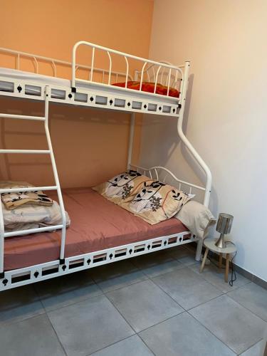 2 łóżka piętrowe w pokoju ze stołem w obiekcie Lo w mieście Audenge